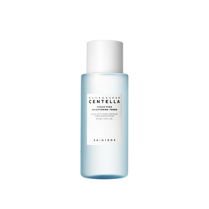 A light blue bottle of skincare product labeled "SKIN1004 - Madagascar Centella Hyalu-Cica Brightening Toner 210ml" boasts being made with Centella Asiatica from Madagascar. The super-hydrating toner by "SKIN1004" is printed at the bottom.
