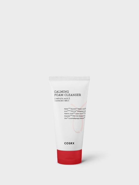 A white tube of COSRX - AC Collection Calming Foam Cleanser 150ml for sensitive skin is displayed against a plain white background. The tube features black and red text detailing the product name and key ingredients like CentellAC-Rx Complex, and it has a red logo at the bottom, highlighting its acne cleanser properties.