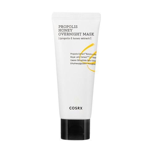 Image of a white tube with a black cap containing "COSRX - Full Fit Propolis Honey Overnight Mask 60ml." The text on the tube highlights key ingredients like Propolis Extract and honey extract, which are known for their hydration benefits. The design is minimalistic with black and gold accents.