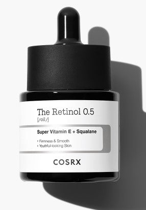 A black dropper bottle of COSRX - The Retinol 0.5 Oil 20ml sits against a white background. The label highlights "Super Vitamin E + Squalane" and promises "Firmness & Smooth," delivering effective anti-aging benefits for youthful-looking skin. The bottle casts a shadow to the right.