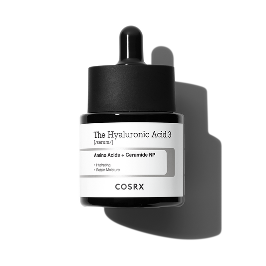 A bottle of COSRX - The Hyaluronic Acid 3 Serum 20ml, a skincare serum infused with NMF (Amino acid complex) and Ceramide NP. The black dropper bottle features a white label with black text, emphasizing its hydrating properties and impressive moisture retention abilities.