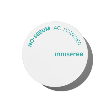 A white, round container of INNISFREE - No-Sebum AC Powder 5g with teal text on the lid. The text reads "NO-SEBUM AC POWDER" and "INNISFREE." This hypoallergenic powder is ideal for troubled skin, controlling excessive sebum. The container casts a slight shadow to the side.