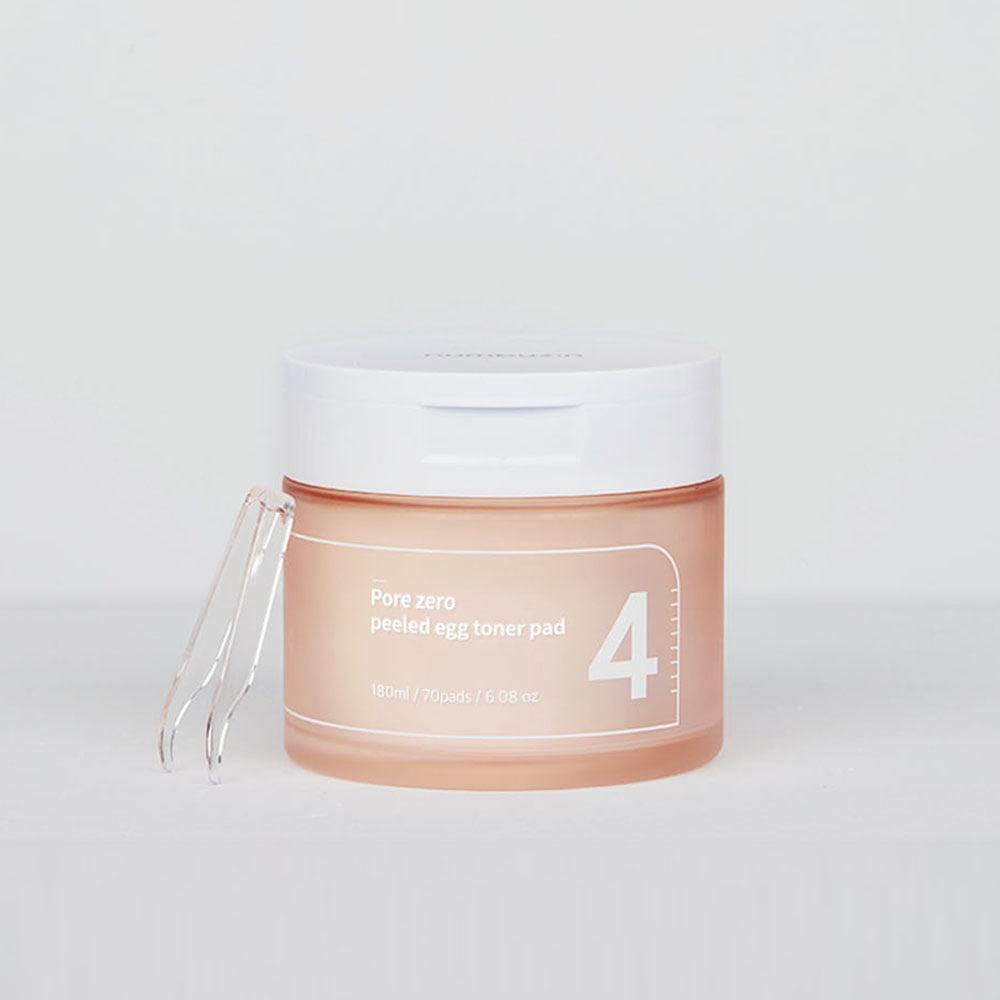 A cylindrical container with a white lid labeled "NUMBUZIN - No.4 Pore Zero Peeled Egg Toner Pad 70 Pads 180ml" in light orange text. The container holds 70 niacinamide-infused toner pads, 180 ml (6.08 oz), and includes a small clear plastic tweezer clipped to the side, perfect for sebum clearing, by Numbuzin.