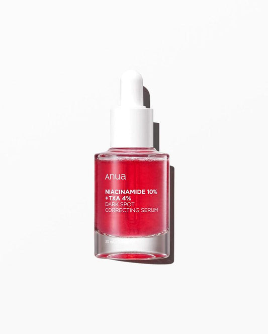 A small, clear bottle labeled "ANUA" contains a vibrant red liquid. The label reads, "ANUA - Niacinamide 10% + TXA 4% Dark Spot Correcting Serum 30ml." Infused with Tranexamic Acid, the serum comes with a white dropper cap and is set against a plain white background.