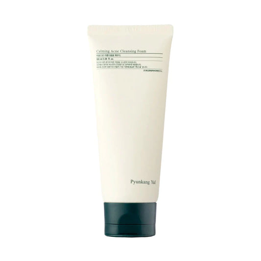 A tube of PYUNKANGYUL Calming Acne Facial Cleanser 100ml is pictured. The predominantly white tube with black text and a dark gray cap has a straightforward, minimalist design. Infused with tea tree, it's perfect for acne-prone skin.