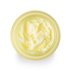 A top-down view of an open container filled with a creamy, yellow substance, likely a skincare product such as BANILA CO - Clean It Zero Cleansing Balm Nourishing 100ml. The container is light yellow and casts a slight shadow beneath.