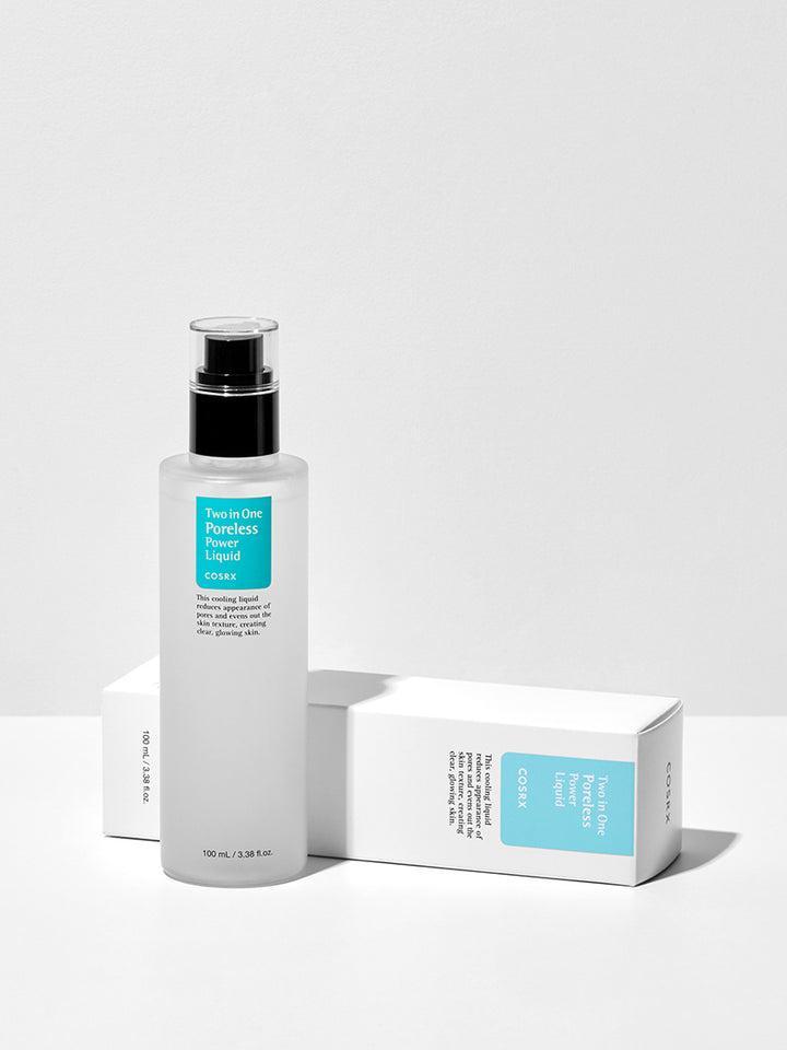 A clear bottle with a black pump, labeled "COSRX - Two in One Poreless Power Liquid 100ml" from COSRX, stands upright on a white surface. Two white boxes with the same product name and teal accents lay flat behind the bottle. This essence-toner promises to tighten pores and smooth skin texture effortlessly.