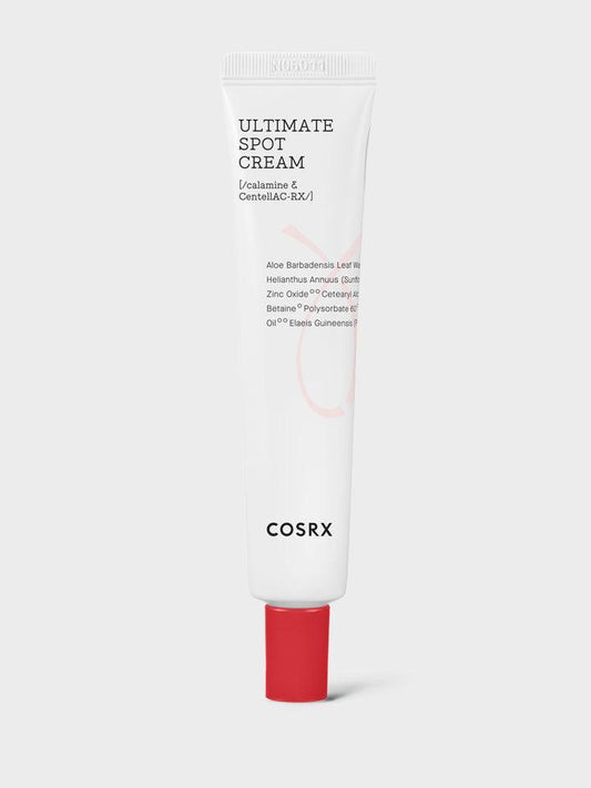 A white tube of COSRX - AC Collection Ultimate Spot Cream 30g with a red cap. The tube features the name of the product and key ingredients such as Calamine and CentellAC-Rx Complex on the front, and other text detailing its contents. This overnight acne solution is set against a plain gray background.