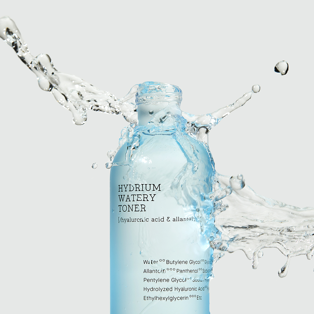 A blue bottle labeled "COSRX - Hydrium Watery Toner 280ml," promoting hydration, with water splashing around it. The label mentions hyaluronic acid and allantoin. This moisturizing toner is set against a light gray background.