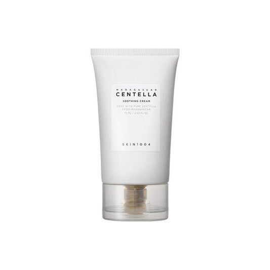 A white tube of SKIN1004 - Madagascar Centella Soothing Cream 75ml with a clear base. The label on the tube includes the product name and description in black text. Formulated with Centella Asiatica Extract, it is designed to assist skin barrier repair. The transparent cap shows the dispensing mechanism inside.